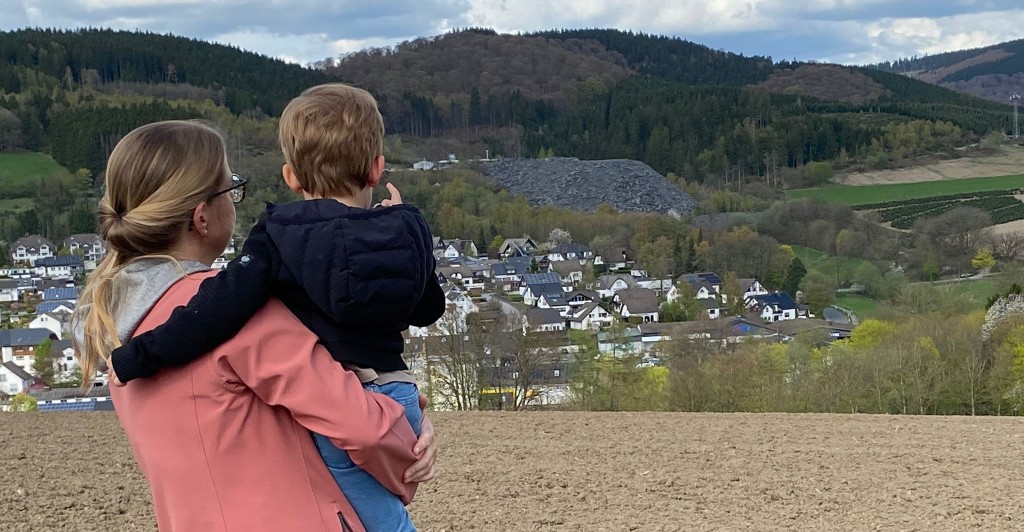 Blick auf Bad Fredeburg und die Schiefergrube Magog – eine Mutter mit Kind zeigt auf die Halde